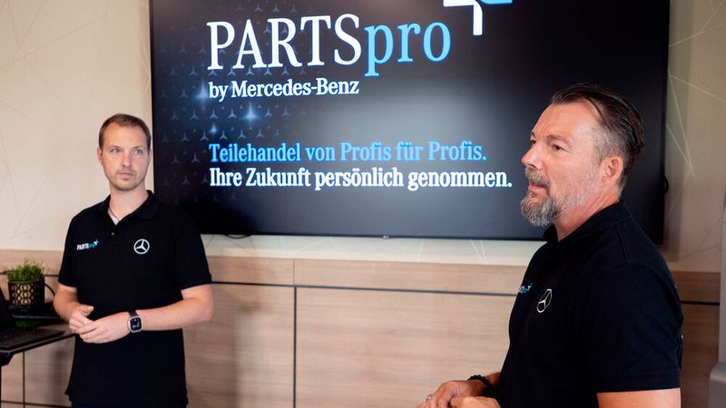 Timo Vössing (LUEG) und Sven Fleischer (Mercedes-Benz Deutschland) im Dialog mit Teilnehmern des Werkstatttreffs. (Bild: Dr. Claudia Posern | LUEG AG & Co. KG)