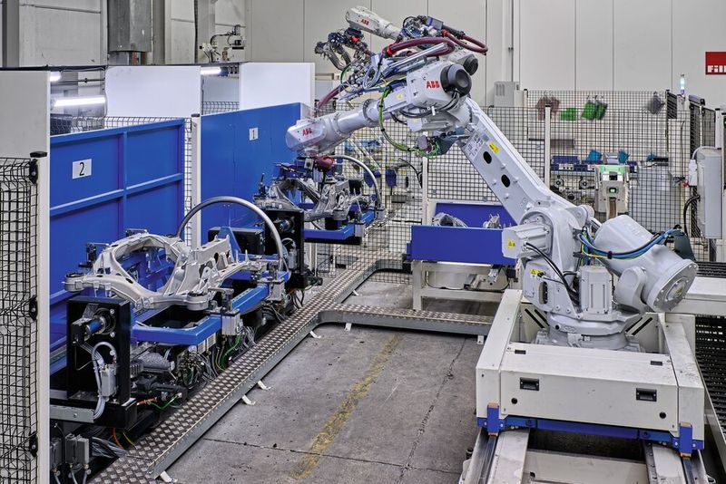 Nach dem Einpressen der passenden Gummilager erfolgt eine End-of-Line-Prüfung der rund 25 kg schweren Teile sowie die anschließende Verpackung in Transportgestelle. Auch dort arbeitet ein Roboter auf Linearachse.  (Bild: Oliver Hallwirth / raumpixel)