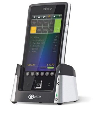 Red Dot Award 2015 - Mobile POS-Lösung NCR Orderman7 von Orderman: Die mobile POS-Lösung NCR Orderman7 ist für den Einsatz in der Gastronomie konzipiert. Das Gerät wird via Multitouch-Display mit Fingern oder Stift sowie über programmierbare Hardware-Tasten bedient. Es beherrscht verschiedene Funkstandards, ist wasserdicht, bruchfest und läuft bis zu 18 Stunden. Der Akku lässt sich rasch per Knopfdruck wechseln. Das sonnentaugliche 5”-Display sitzt in einem ergonomischen, mit einer Hand bedienbaren Metall-Kunststoff-Gehäuse.  (Bild: Red Dot)