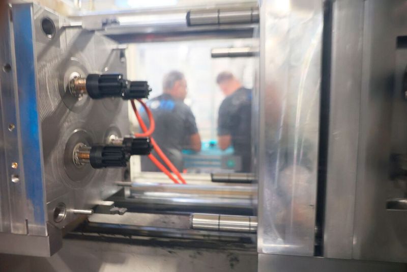 The parts just before ejection. Before this step, undercuts must be cleared, and cores pulled. For this, the plate is moved on the nozzle side — the gap in the mould on the right illustrates the travel path before the opening at the parting line. (Source: Pergler Media)