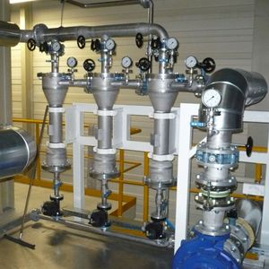 In der Praxis können mehrere Zentrifugalabscheider parallel angeordnet werden. Das Bild zeigt eine sogenannte Batterie, bestehend aus drei Zentrifugalabscheidern. Die Summe der Einzeldurchsatzleistung jedes Zyklons ergibt die Gesamtdurchsatzleistung der Batterie.(Bild:  Wolftechnik)