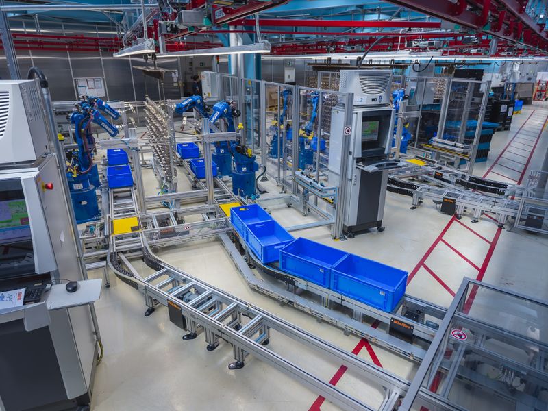 Die befüllten KLTs fahren über eine FMS-Förderstrecke von Minitec zum Lagerregal, leere Boxen werden den Robotern wieder zur Verfügung gestellt.   (Bild: Yaskawa Europe GmbH)