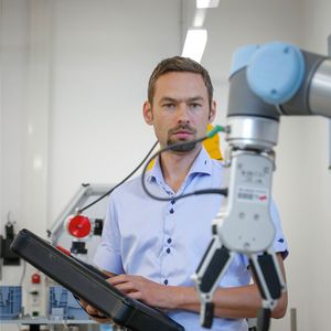 Stefan Trabesinger, Mitarbeiter am Institut für Fertigungstechnik der TU Graz, arbeitet mit einem kollaborativen Roboter in der Fabrik.(Bild:  Lunghammer / TU Graz)