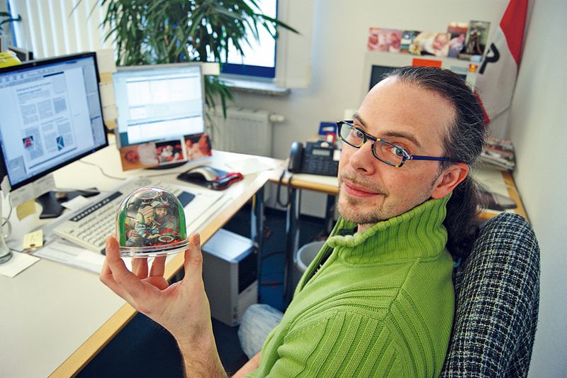 Romantisch: Johannes Rath aus der Abteilung Layout schüttelt eine Schneekugel mit dem Bild seiner Tochter. (Archiv: Vogel Business Media)