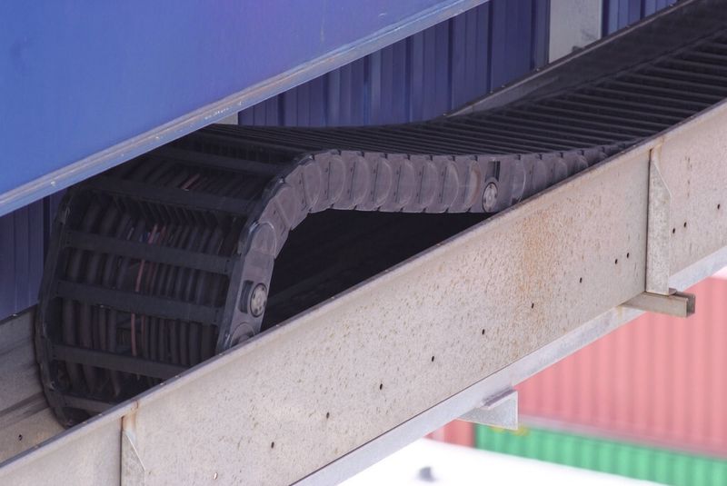 Einer der ersten Ship-to-Shore-Krane, der frühzeitig mit einem Energiekettensystem ausgerüstet worden ist, befindet sich im von der Kramer Group betriebenen Zollgebiet des Rotterdam Container Terminal (RCT). Hier wird ein igus-System eingesetzt, das aus stabilen Energieketten „5050R“, „Chainflex“-Leitungen und einem Edelstahlrinnensystem besteht. Schon sehr früh ist bei diesem System auch der schwimmend gelagerte Mitnehmer – eine Konstruktion von igus – eingesetzt worden. (Bild: Höltkemeier)