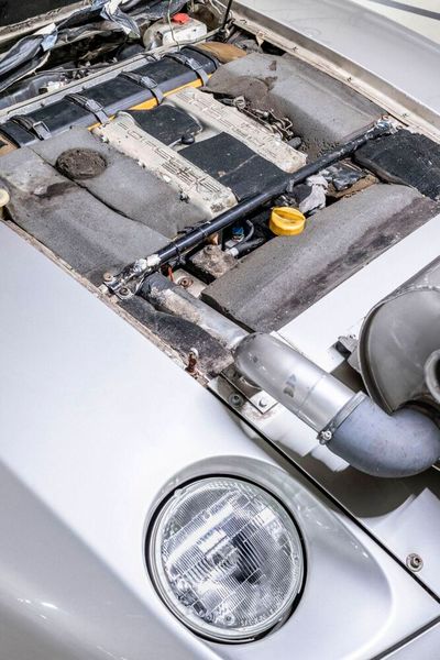 Der Prozess des Ansaugens wurde in ein großes Fass – im Ingenieurssprech: Ansaugmündungsdämpfer mit bestmöglicher Dämmung – verlagert. Von diesem führten Leitungen zum Triebwerk im vollständig bis in den letzten Winkel gekapselten Motorraum. (Bild: Porsche)