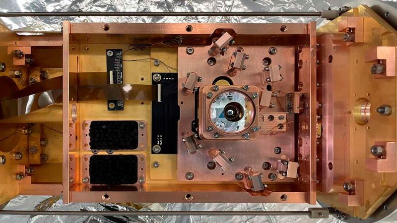 Aufsicht auf den Versuchsaufbau: Die Chip-Falle, in der die Versuche stattfanden, befindet sich in dem Behälter unterhalb des runden, silberfarbenen Objektivs. (Bild: Tobias Sägesser / ETH Zürich)