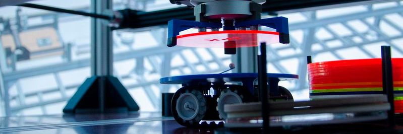 Smarte Fabrik: Bearbeitete Rohlinge werden auf ein fahrerloses Transportsystem (FTS) gehoben.(Bild:  Fraunhofer IPK)