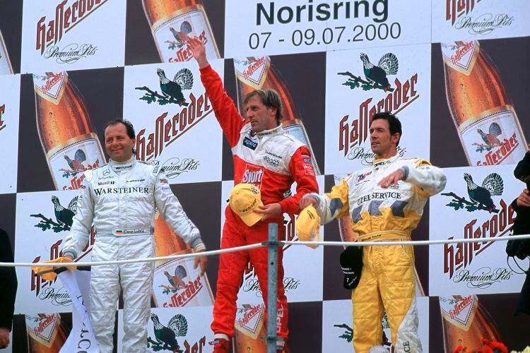 Erster Sieg im Rahmen der neuen DTM: Joachim Winkelhock als Gewinner der „200 Meilen von Nürnberg“ im Jahr 2000. Neben ihm zwei weitere DTM-Ikonen: Klaus Ludwig (li.) und Manuel Reuter (re.). (Opel)
