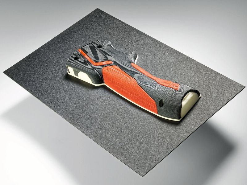 Accelerated time-to-market: the Freeformer 300-3X uses original materials to produce, for example, functional power tool handles, in this case from ABS (Terluran GP35, black), TPU (Desmopan 9385A, red) and a support material (Armat 21, white). (Arburg)