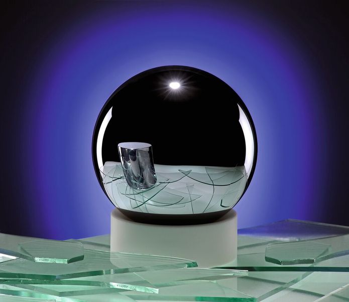 Das neue Urkilo – exakt bis in die Ewigkeit: Im Pariser Vorort Sèvres hält das Internationale Büro für Maße und Gewichte das 1889 geschaffene Urkilo sicher unter Verschluss. Es besteht aus einer Platin-Iridium-Legierung (90 %/10 %) und misst jeweils 39,17 mm in der Höhe und im Durchmesser. Regelmäßige Überprüfungen und Messungen belegten vor gut fünfzehn Jahren die erschreckende Erkenntnis: Das Urkilo ist leichter geworden. Und zwar um 50 Millionstel Gramm in den vergangenen 100 Jahren. Diese Feststellung führte zum Weltgipfeltreffen der Metrologen. Mit Revision der internationalen SI-Einheiten am 20.5.2019 ist fortan das Kilogramm wie auch der Meter und die Sekunde über unveränderliche Naturkonstanten definiert. Zur Ablösung des Urkilo-Zylinders als Masse-Normal haben Wissenschaftler in der Physikalisch-Technischen Bundesanstalt eine hochreine Silizium-Einkristall-Kugel (99,9995 %) hergestellt, deren Silizium-Atome  gezählt und die Atommasse bestimmt. In der Spiegelung der hochpolierten Si-Kugel ist der Urkilo-Zylinder zu sehen.  (Bild: Physikalisch-Technische Bundesanstalt Braunschweig)