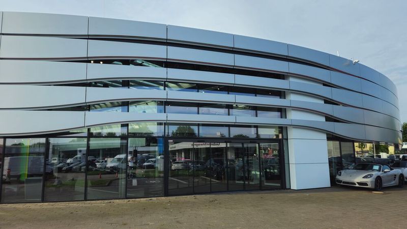 Erinnert an ein Helmvisier: der neu gestaltete Haupteingang des Porsche-Zentrums Aachen.  (Bild:  Automobilhändlergruppe Fleischhauer-Franz)