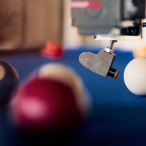 Bevor der Roboter einen Stoß ausführt, erfasst eine Kamera zunächst die Position aller Kugeln auf dem Tisch. Anschließend berechnet das System innerhalb weniger Augenblicke den optimalen Spielzug und führt diesen autonom aus. (Bild:  P. Pollmeier/HSBI)