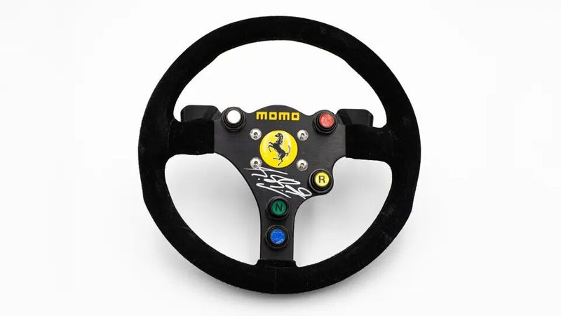 Ein Momo Scuderia Ferrari 412 T2 von Michael Schumacher (und von im signiert) mit einem Schätzwert von 4.000 bis 6.000 Euro kann man sich ebenfalls schön in eine Vitrine stellen.  (Bild: RM Sothebys)