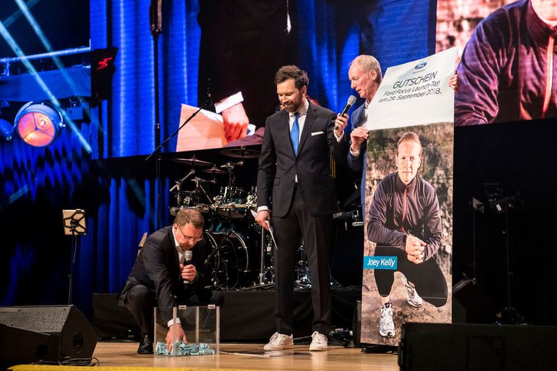 Auf der Ford-Händlerfete, die Ingo Nommsen moderierte (Mitte), verloste Ford-Deutschland-Chef Wolfgang Kopplin (re.) Joey Kelly als Stargast für die Ford-Focus-Einführung in einem Autohaus. Ford-Händlerverbandspräsident Johann Gesthuysen (li.) spielte die Glücksfee. (Mareen Meyer/Blond Marketing)