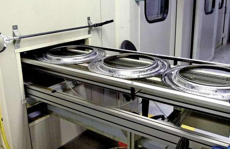 Die Stirnböden verlassen die Umformpresse und werden der Montagelinie zugeführt, wo sie auf verschiedenen Stationen mit der Trommel, die ebenfalls zugefördert wird, „verheiratet“ werden. Bild: Kuhn (Archiv: Vogel Business Media)