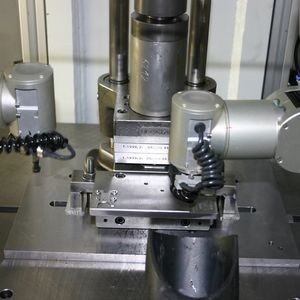 Der Arbeitsbereich des PCG-Pressensystems; von links werden per Roboter die Werkstücke zugeführt und in das Biegewerkzeug eingelegt, von rechts holt ein weiterer Roboter die fertigen Präzisionsteile aus dem Werkzeug und legt sie ab.