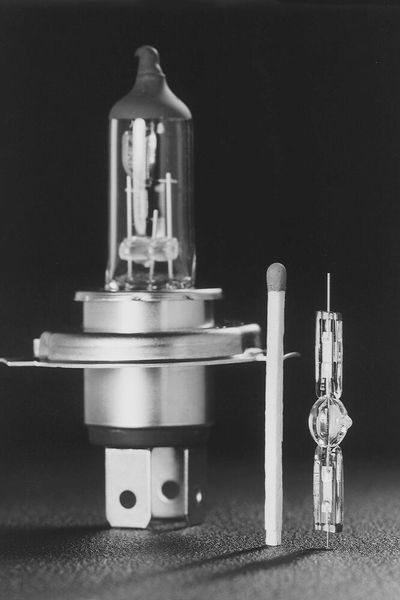 Eine H4-Halogenlampe (l.) im Größenvergleich mit dem Xenon-Glaskolben der D1-Lampe. Nach vielen Jahren erfolgreichen Einsatzes begann das Xenonlicht ab Ende der Achtzigerjahre das Halogenlicht zu ergänzen bzw. zu ersetzen. (Bild: Hella)
