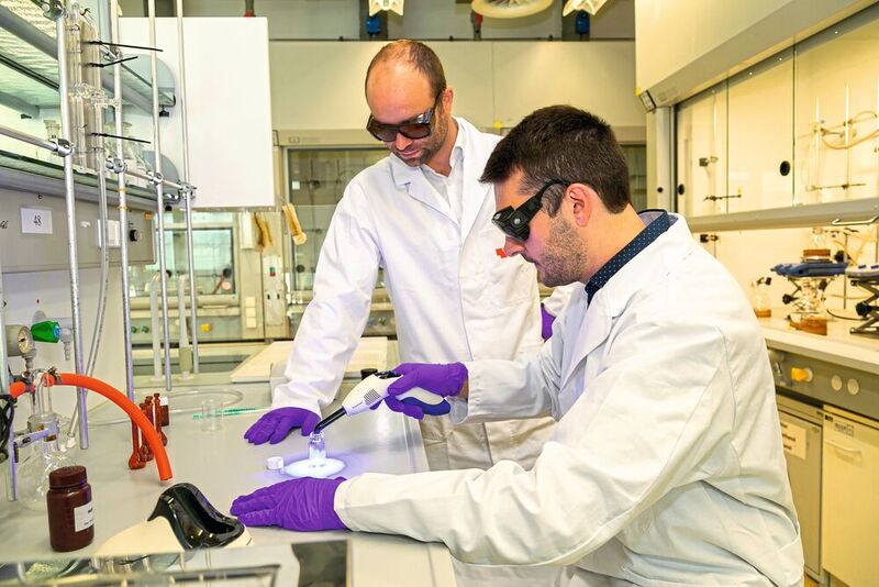 Michael Haas (l.) und der Doktorand Manfred Drusgala demonstrieren die Aushärtung einer Kunststoffpaste mittels einer herkömmlichen Zahnarztlampe – dank des germaniumbasierten Photoinitiators funktioniert das ohne UV-Licht. 
