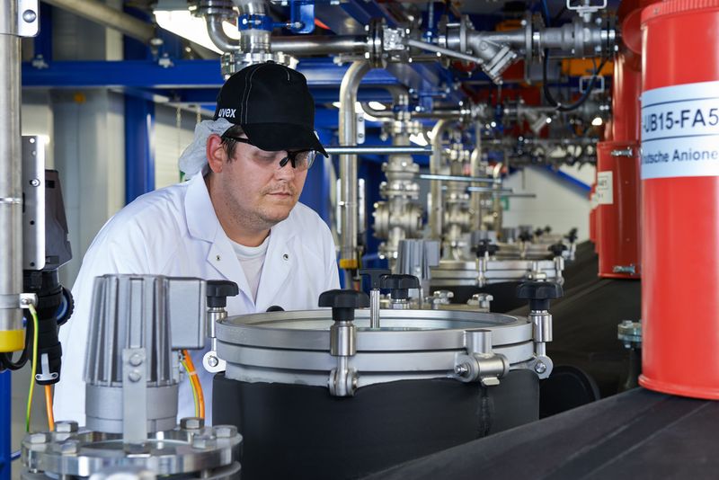 Lanxess-Mitarbeiter bei der Sichtkontrolle der Abfüllnusche in der neuen Abfüllungs- und Verpackungshalle. (Bild: Lanxess)
