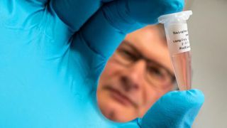 Dr David Kaiser holding a sample from a nasal swab, which is analyzed for specific biomarkers using the developed sensor. (Source: Jens Meyer/ University Jena)
