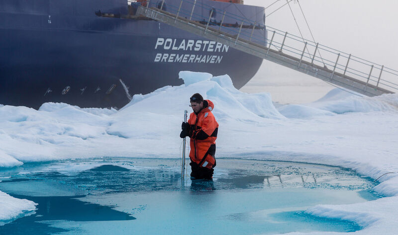 Abb. 5: Meereisphysiker Dr. Marcel Nicolaus vermisst während der Polarstern-Expedition ARK-XXVII-3 auf einer Eisscholle die Tiefe eines Schmelzwassertümpels. (Bild: Stefan Hendricks, Alfred-Wegener-Institut)