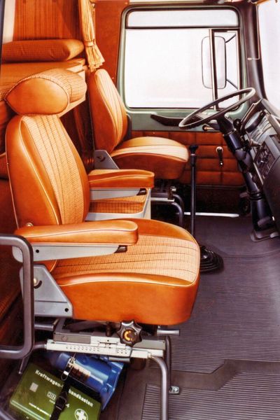 1971 übernahm MAN den traditionsreichen Bus- und Lkw-Bauer Büssing. Damit kam zusätzlich eine neue Bauweise in das MAN-Produktportfolio mit unmittelbarer Auswirkung auf die Gestaltung des Fahrerhauses: der Unterflurmotor. Der fand sich nicht mehr unter der Kabine, sondern hing rechts seitlich am Rahmen. Daher entfiel - wie man auf dem Foto sehen kann – der Motortunnel. Das Resultat: ein ebener Boden im F8-Fahrerhaus, viel Platz und Bewegungsraum für den Fahrer. Nach ein paar Jahren war Schluss mit dieser Bauart aus Gründen des Lärmschutzes.  (Bild: MAN)