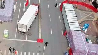 Professional sterilization teams can be seen outside the main entrance of the Huanan Seafood Wholesale Market in Wuhan, China in March 2020, shortly after its closure.  (Source: China News Service/ Wikipedia)