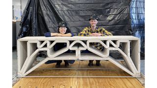 Die Postdoktorandin Hajin Kim‑Tackowiak (links) und der Doktorand Zane Schemmer vom MIT Department of Civil and Environmental Engineering posieren mit der von ihnen entworfenen und belastungstesteten 3D‑gedruckten Betonbrücke. (Foto: Forschende des MIT)