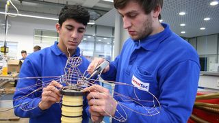 Die Ceramtec-Auszubildenden Aliekber Düzgün (links) und Steffen Benzing verbinden den vorderen Drahtkörper der "Wire-Bee" mit
der Ziehwalze.  (Bild: Ceramtec)