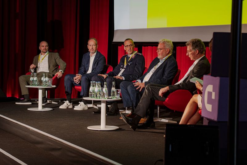 Beim Panel Talk diskutieren (v. l.) Holger Lehmann, Martin Wibbe, Christof Opolny, Stefan Hagen, Christoph Heusgen und Sarah Yvonne Elsser über das Thema „Wie Innovation unter Effizienzdruck, Souveränitätsanforderungen und dem Einsatz von KI gelingt“. (Bild: Conet)
