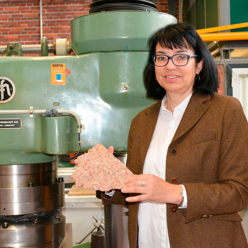 Prof. Dr. Sylvia Stürmer zeigt einen Teil eines Leichtbeton-Mauersteins aus dem Technischen Rathaus von Tübingen – ein Beispiel für die Nutzung von Abrissmaterial in der Nachkriegszeit.
