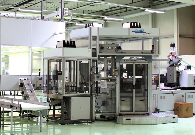 Komplexe Reinraumfertigung: Spritzblasformmaschine, Automationsanlage und Prüf-Drehtisch mit jeweils eigener Laminarflow-Einhausung. Vollautomatisierte Einschleusung in den Reinraum über gekapselte Förderbänder. (Bild: Schilling)