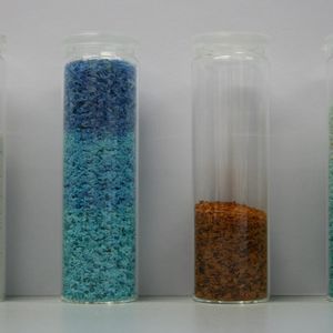 Abtrennung von Schwermetallen mit Chitosan als Flockungsmittel: links reine Chitosan-flocken, daneben Chitosanflocken mit gebundenem Kupfer (blau), Eisen (rot) und Nickel (grün)