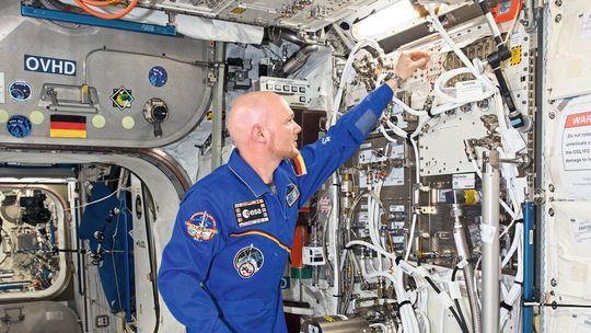 L'astronaute de l'ESA Alexander Gerst installe le « Electromagnetic Levitator » (EML) à bord de l'ISS. C'est sur cet instrument que Alexander Gerst a ensuite réalisé les essais de l'EMPA avec des verres métalliques.(Source :  NASA)