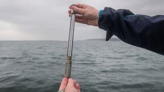 Karen Helen Wiltshire hält ein Termometer. An der „Helgoländer Straße“ läuft seit 1962 täglich die detaillierteste Langzeitüberwachung des Meeres. Seit fast 60 Jahren kämpft sich jeden Tag ein kleines Forschungsschiff aus dem Hafen auf Helgoland in die offene Nordsee. In den vergangenen 60 Jahren betrug die durchschnittliche Erwärmung des Wassers an der Helgoländer Straße 1,9°C, was etwa dem Doppelten der Erwärmung des globalen Ozeans entspricht. (Bild: Alfred-Wegener-Institut / Esther Horvath)