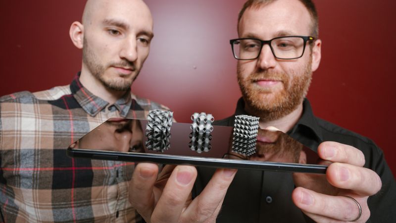 Ästhetische Kühlmittel: Die Doktoranden Thorben Trodler (l.) und Michael Fries (r.) feilen an filigranen Strukturen aus Nickel-Titan, durch die Luft oder Wasser strömen kann, um Wärme aufzunehmen und abzugeben. Die Legierung wird für Experimente Schicht für Schicht 3D-gedruckt.(Bild:  Universität des Saarlandes/Oliver Dietze)