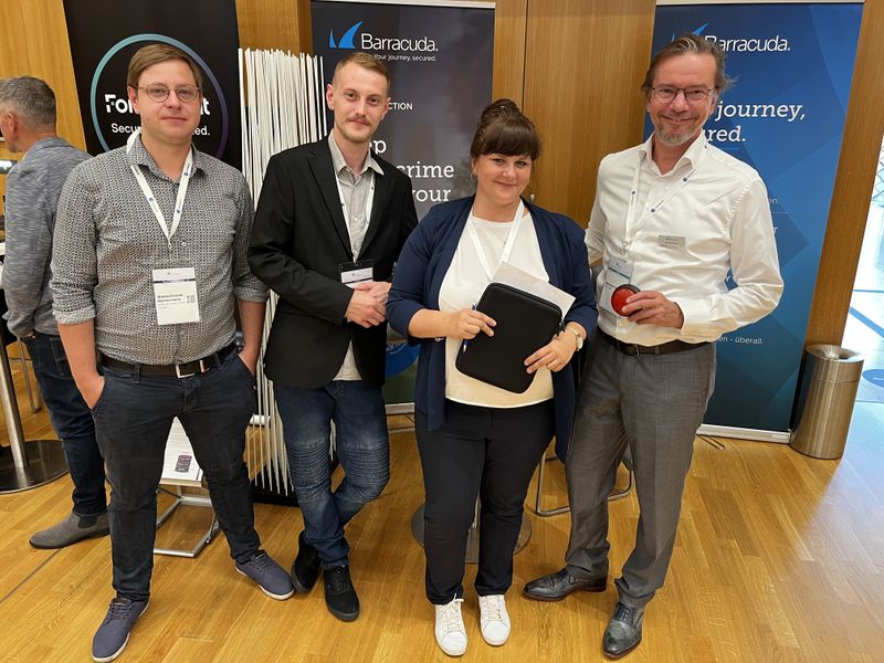 Kati Rabe, Infinigate, erklärt (v. l.) Wjatscheslaw Mordwinzew und Andreas Loos, Network Engineering, und Bernhard Oertel, Barracuda, wie das Scannen der Besucher mit dem Ipad funktioniert. (IT-BUSINESS)