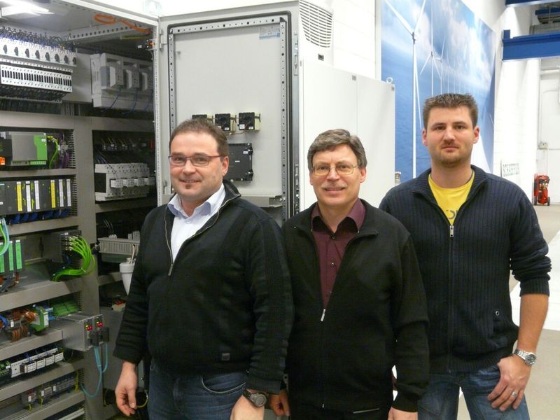 Die Elektroplaner des Schaeffler-Prüfanlagenbaus Leonhard Keller (links) und Heiko Gründl (rechts) mit Projektleiter Reinhold Korn (Mitte) vor einem der Schaltschränke des Prüfstandes. (Schaeffler)