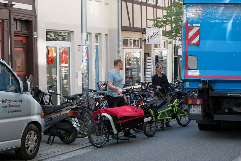 Wenn Pkw und Lkw, „normale“ Fahrräder und Cargo-Bikes um Parkraum buhlen wie in diesem Bild, wird es sehr schnell ziemlich eng. Für Lastenfahrräder gibt es inzwischen professionelle Lösungen.