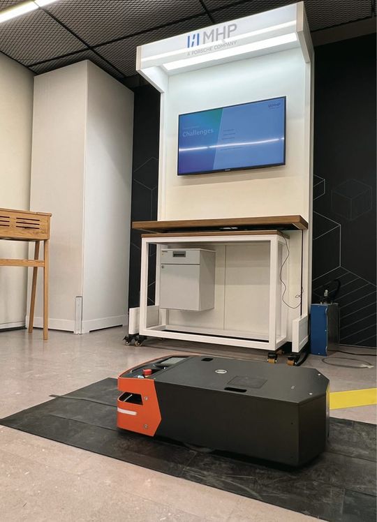 (Der MHP FleetExecuter wird im Digital Builders Showroom von Amazon Web Services (AWS) in München anhand eines fahrerlosen Transportsystems gezeigt. Bild: MHP)