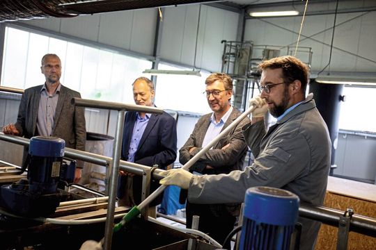 Dr. Johannes Oelerich (Melund), Prof. Matthias Grottker und Vizepräsident Frank Schwartze der TH Lübeck schauen Dr. Kai Wellbrock bei einer Probenentnahme zu.(Bild:  TH Lübeck)