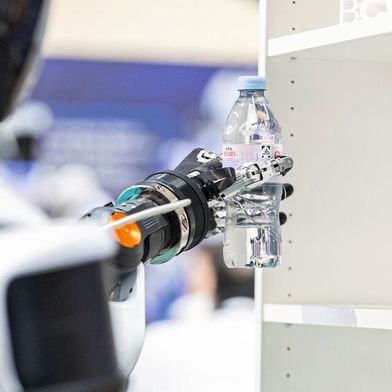 A humanoid robot retrieves a drink from the shelf and places it on the counter. The demonstration at Bosch Connected World 2026 showcased the core capabilities of humanoid systems in a specific handling process. (Image:  SCHUNK SE & Co. KG)