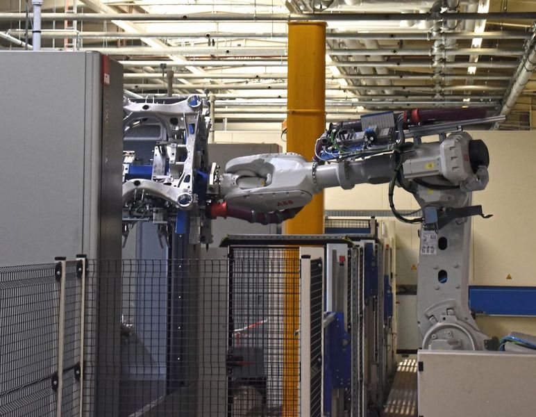 Ein auf einer rund 20 Meter langen Linearachse fahrender Sechs-Achs-Knickarmroboter verkettet die drei Bearbeitungszentren mit den vor- und nachgelagerten Stationen zur Rohteileentgratung und zum Entgraten und Reinigen der Fertigteile. (Bild: P. Kemptner)