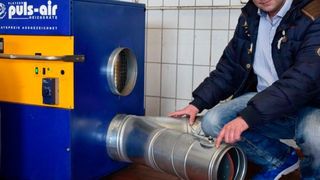 Marco Barnewold freut sich über den hohen Wirkungsgrad seiner Werkstattheizung. Ein zweites Rohr versorgt die Aufbereitungshalle mit Warmluft.        (Rubbel)