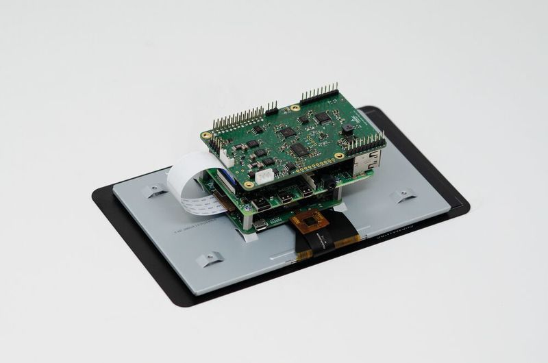 Bild 3: Single-Board-Computer Raspberry Pi 4 mit aufgesetztem TOSV-Board, beides montiert auf der Rückseite eines Touchscreen-Displays. (Trinamic)