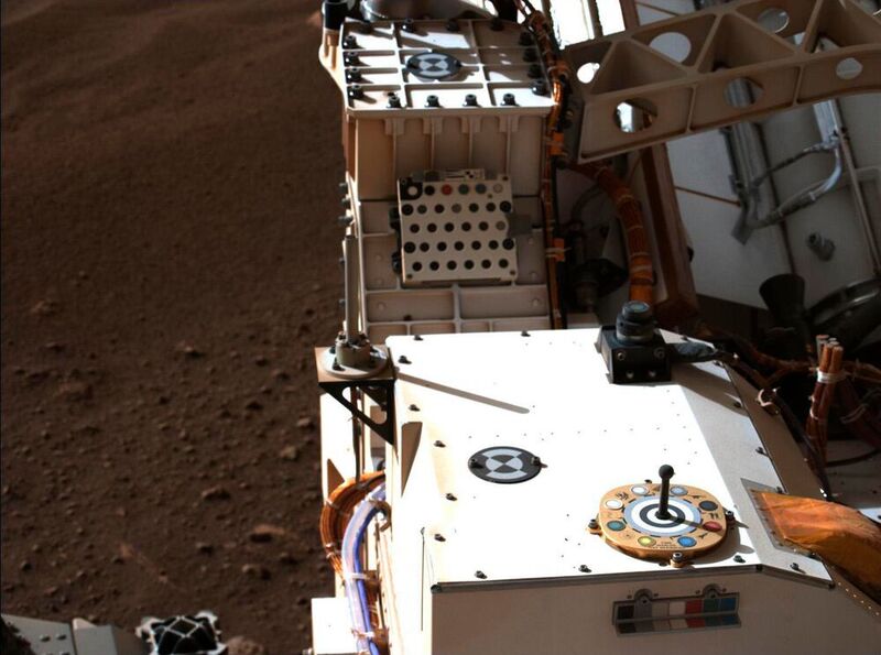 Mastcam-Z, ein Paar an zoombaren Kameras an Bord des NASA-Rovers Perseverance, hat am 20. Februar 2021, dem zweiten Marstag (Sol) der Perseverance-Mission, zum ersten Mal sein Kalibrierungsziel aufgenommen. In diesem Bild in natürlichen Farben sind das primäre Farb- und Graustufen-Kalibrierungsziel der Mastcam-Z (das bunte kreisförmige Objekt rechts im Vordergrund) sowie das sekundäre Kalibrierungsziel der Kamera (der kleine bunte L-Bügel direkt unter dem primären Ziel) zu sehen. Das Mastcam-Z-Team verwendet diese Ziele zur Kalibrierung von Bildern des Marsgeländes, um Änderungen der Helligkeit und des Staubes in der Atmosphäre im Laufe des Tages auszugleichen. (NASA/JPL-Caltech/ASU/MSSS/NBI-UCPH)