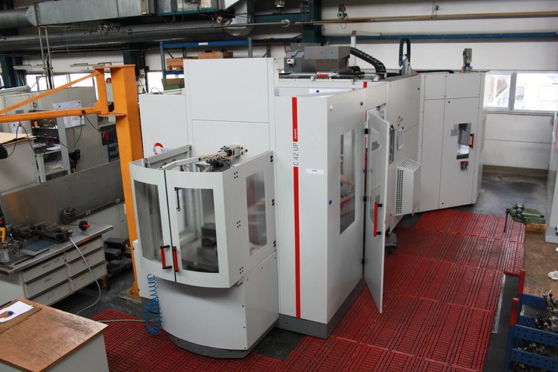 5-Achsen-CNC-Hochleistungs-Bearbeitungszentrum C 42 U mit dem frontseitig angedockten Palettenwechsler PW 850 und dem im Vordergrund befindlichen Rüstplatz in der mechanischen Fertigung bei Reis Robotics im Stammwerk Obernburg. (Bild: Hermle)