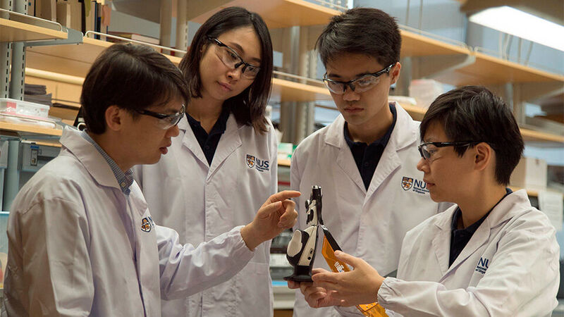 Benjamin Tee (links) und sein Team haben die neue E-Haut an einer Roboterhand erprobt. (NUS National University of Singapore)