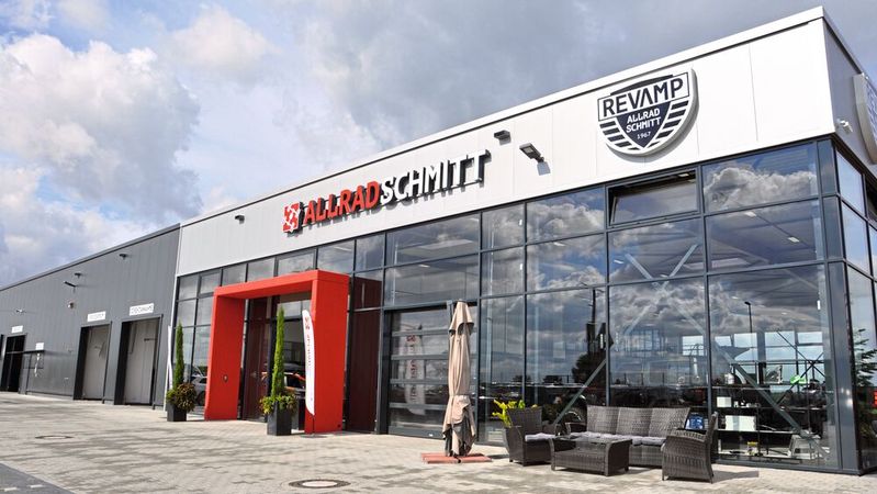 Das Logo der Tuningmarke Revamp ist gut sichtbar an der Fassade des Neubaus von Allrad Schmitt angebracht. Das Logo der Tuningmarke Revamp ist gut sichtbar an der Fassade des Neubaus von Allrad Schmitt angebracht.